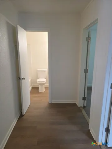 a view of a room with wooden floor and a toilet