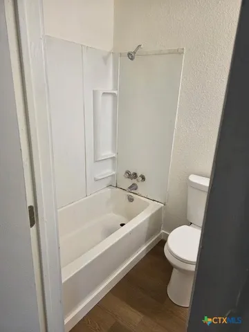 a white toilet sitting next to a bath tub
