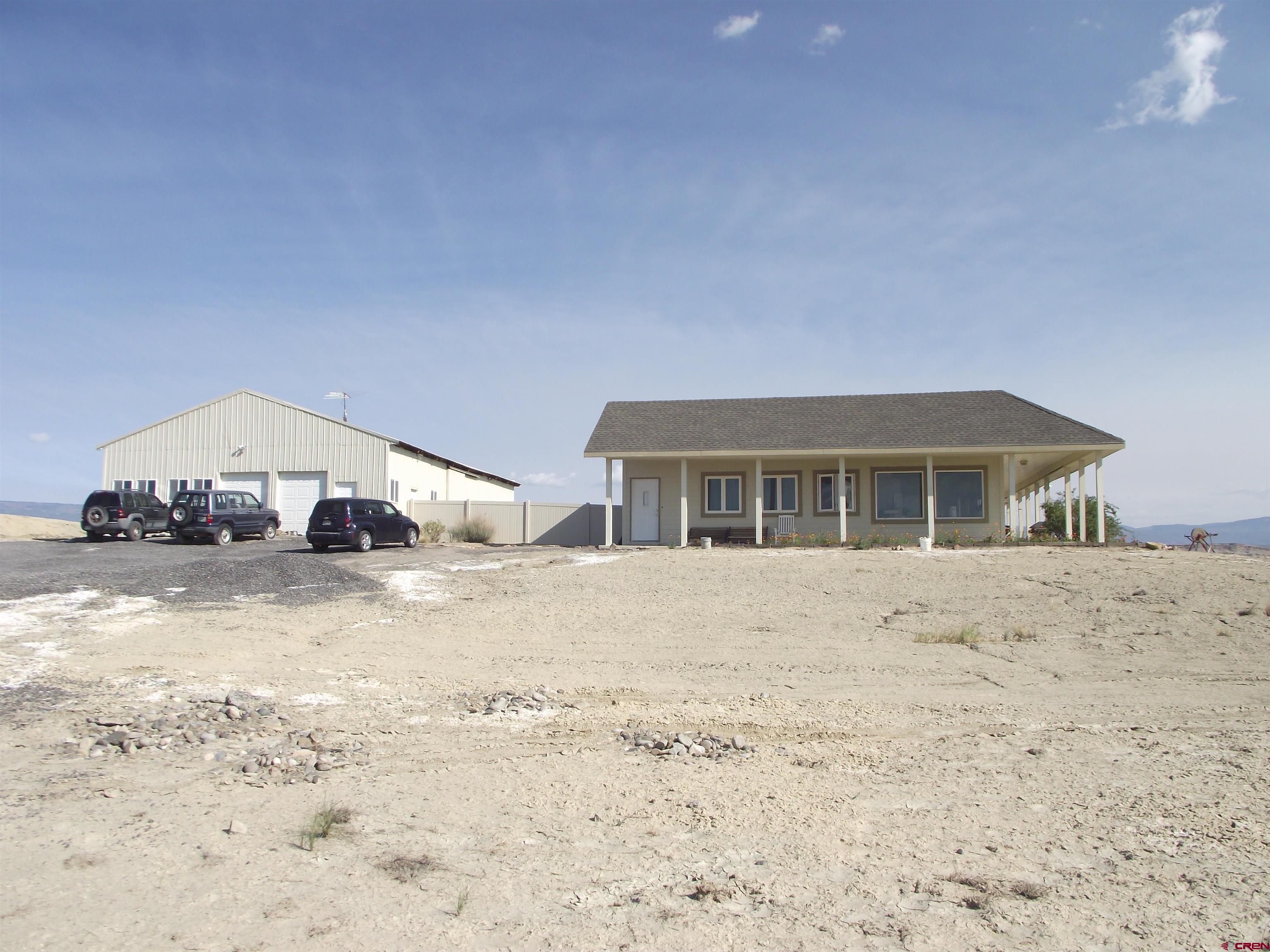 6742 2200th Road Delta, CO 81416 - Photo 14 of 45 a big house with a bed and wooden fence