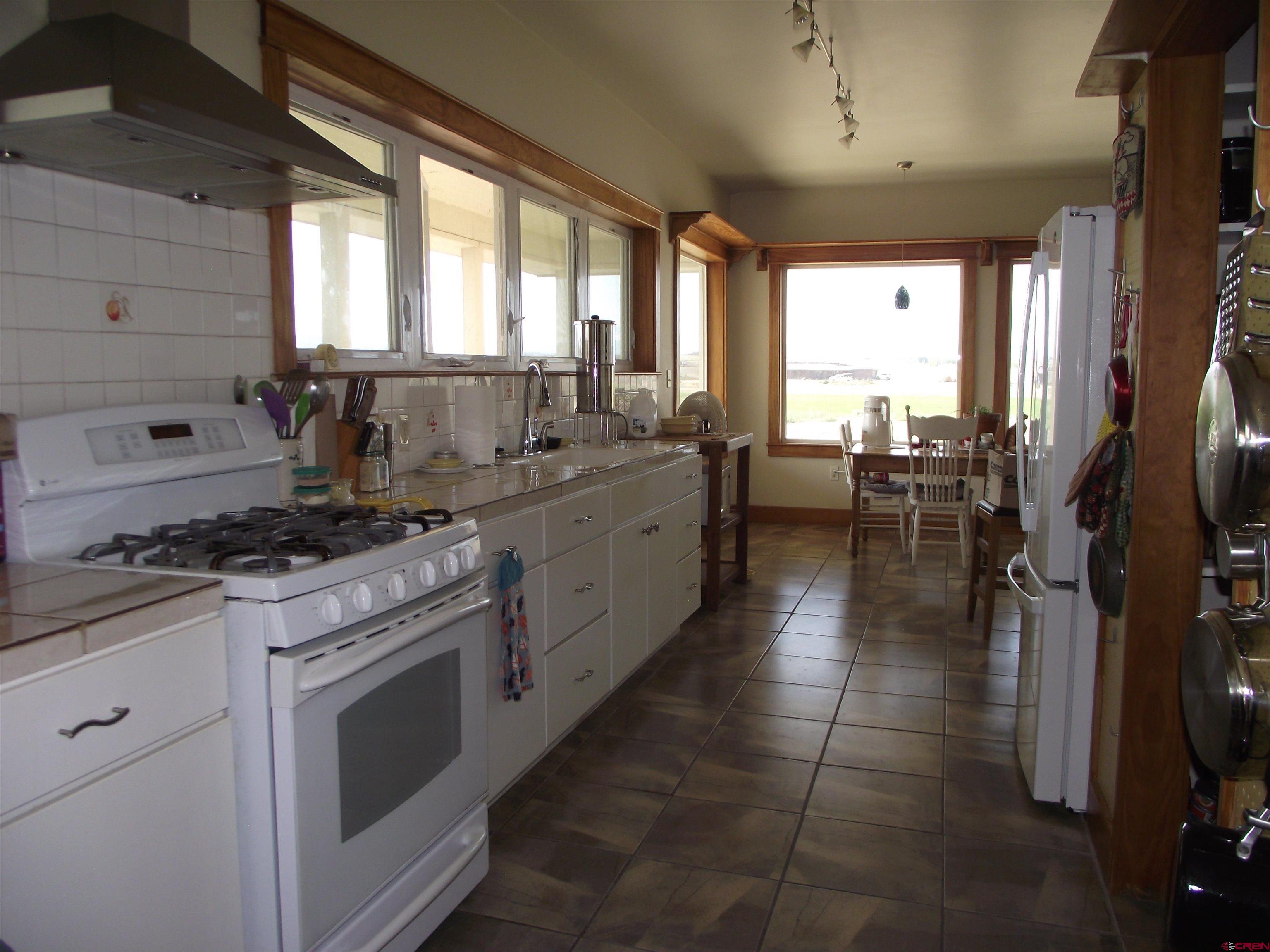 6742 2200th Road Delta, CO 81416 - Photo 22 of 45 a kitchen with a stove a sink and a refrigerator