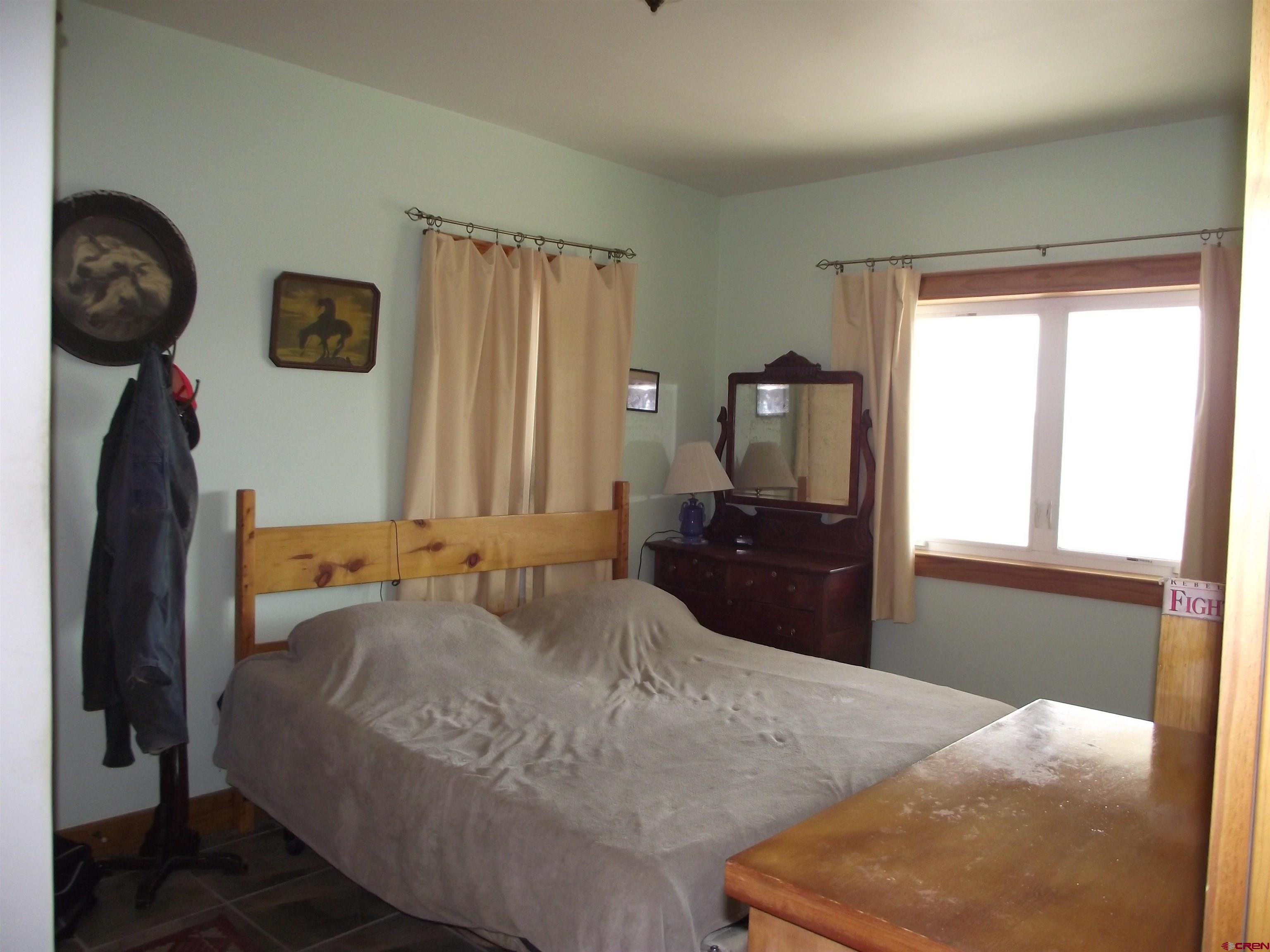 6742 2200th Road Delta, CO 81416 - Photo 30 of 45 a bedroom with a bed and a chandelier