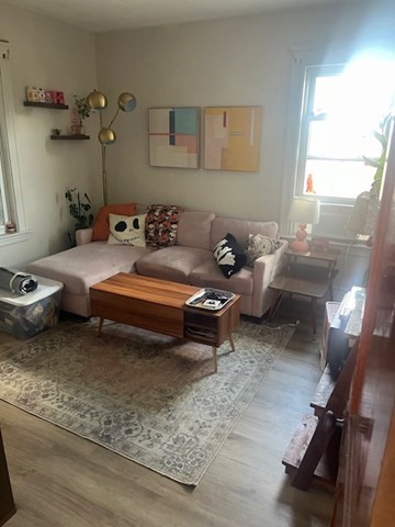75 Winthrop Street Woonsocket, RI 02895 - Photo 17 of 30 a living room with furniture and a gym machine next to a window