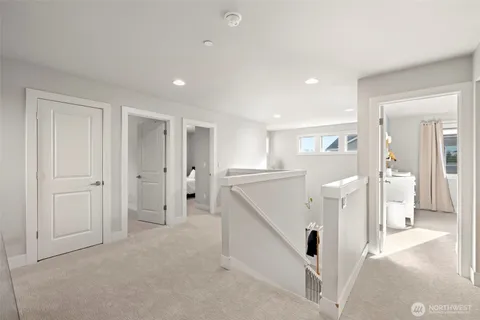 a view of a kitchen with white cabinets and wooden floor
