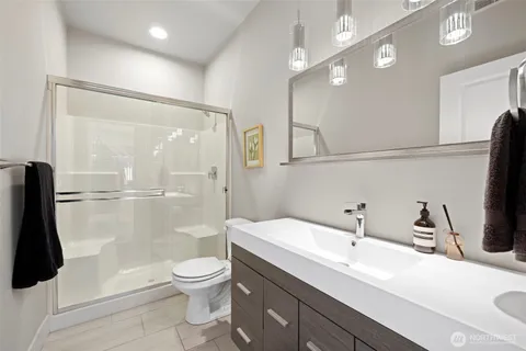 a bathroom with a sink a toilet and a large mirror