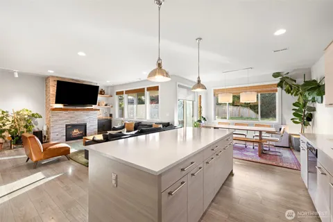 a large living room with stainless steel appliances granite countertop a sink a stove and a flat screen tv