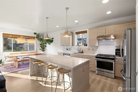 a kitchen with stainless steel appliances granite countertop a stove a sink and a microwave