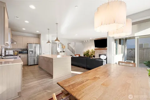 a large kitchen with kitchen island a counter top space a sink stainless steel appliances and cabinets