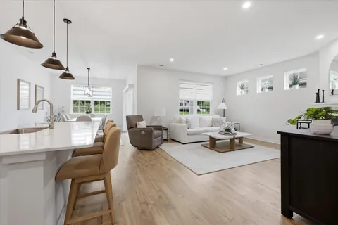 a living room with furniture a fireplace and kitchen view