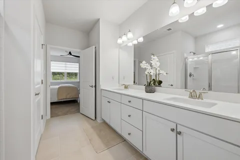 a en suite bathroom with a double vanity sink and a mirror