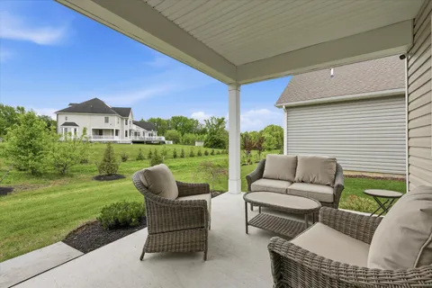 a view of a patio with couches chairs and a yard