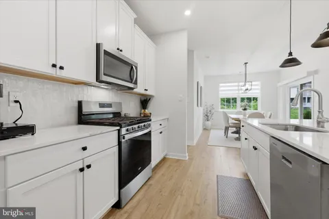 a kitchen with stainless steel appliances kitchen island granite countertop a sink and a refrigerator