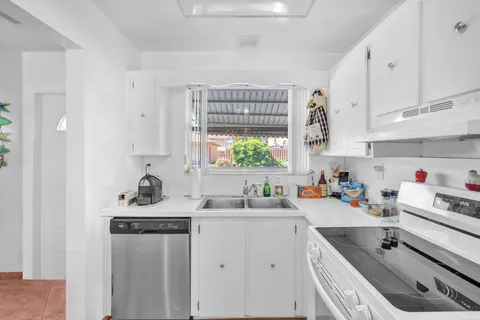 a kitchen that has a sink cabinets counter space and a window