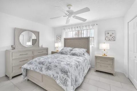 a bedroom with a bed a mirror on dresser and a chandelier