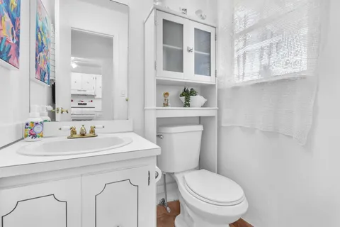 a bathroom with a sink a toilet and a mirror