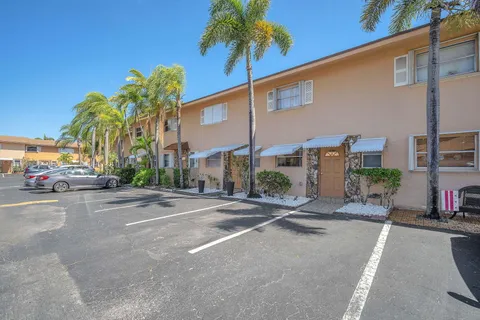 a row of palm trees in front of a building