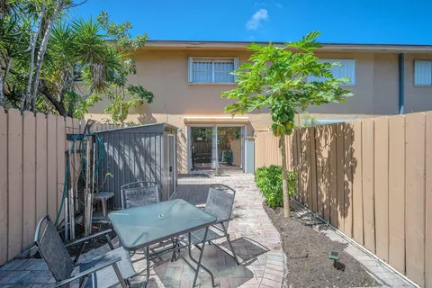 a view of a house with backyard and sitting area