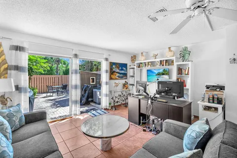 a living room with furniture a flat screen tv and a large window