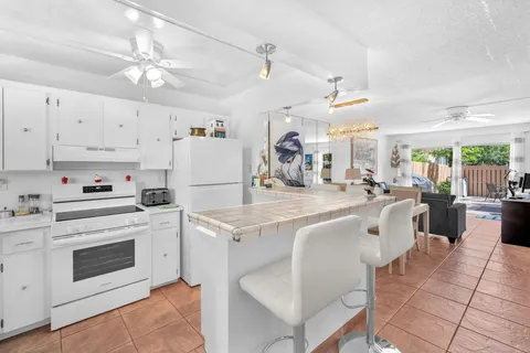 a kitchen with cabinets a sink and white appliances