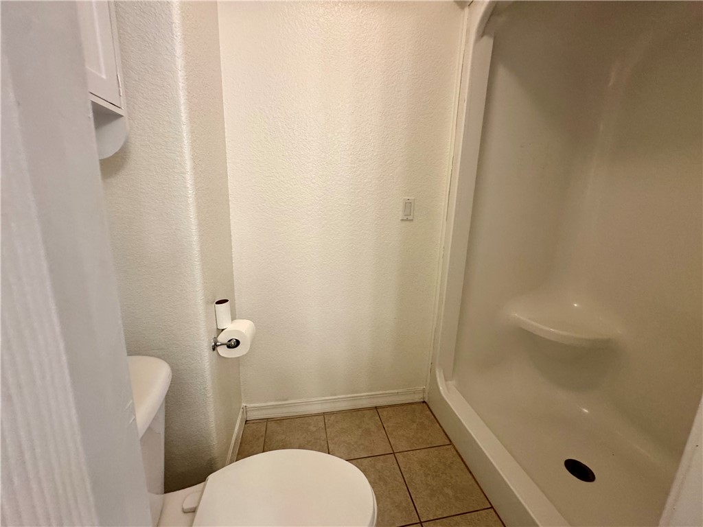 1197 Ridgeview Lane Russellville, AR 72802 - Photo 25 of 44 Compact bathroom featuring a white toilet, tile flooring, and a stand-up shower with an integrated shelf
