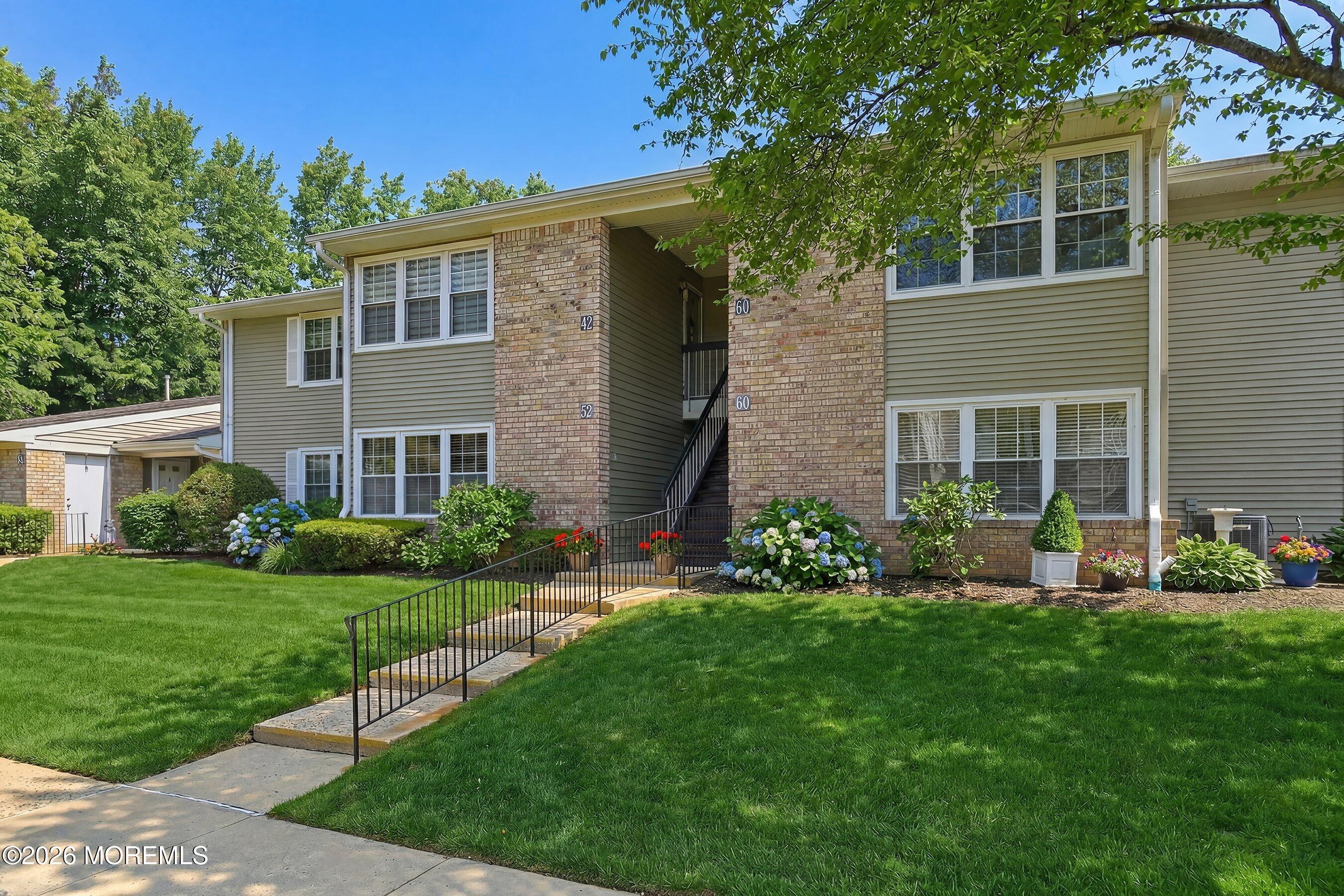 52 Honeysuckle Lane, Unit 220 Red Bank, NJ 07701 - Photo 1 of 25 a front view of a house with garden and porch