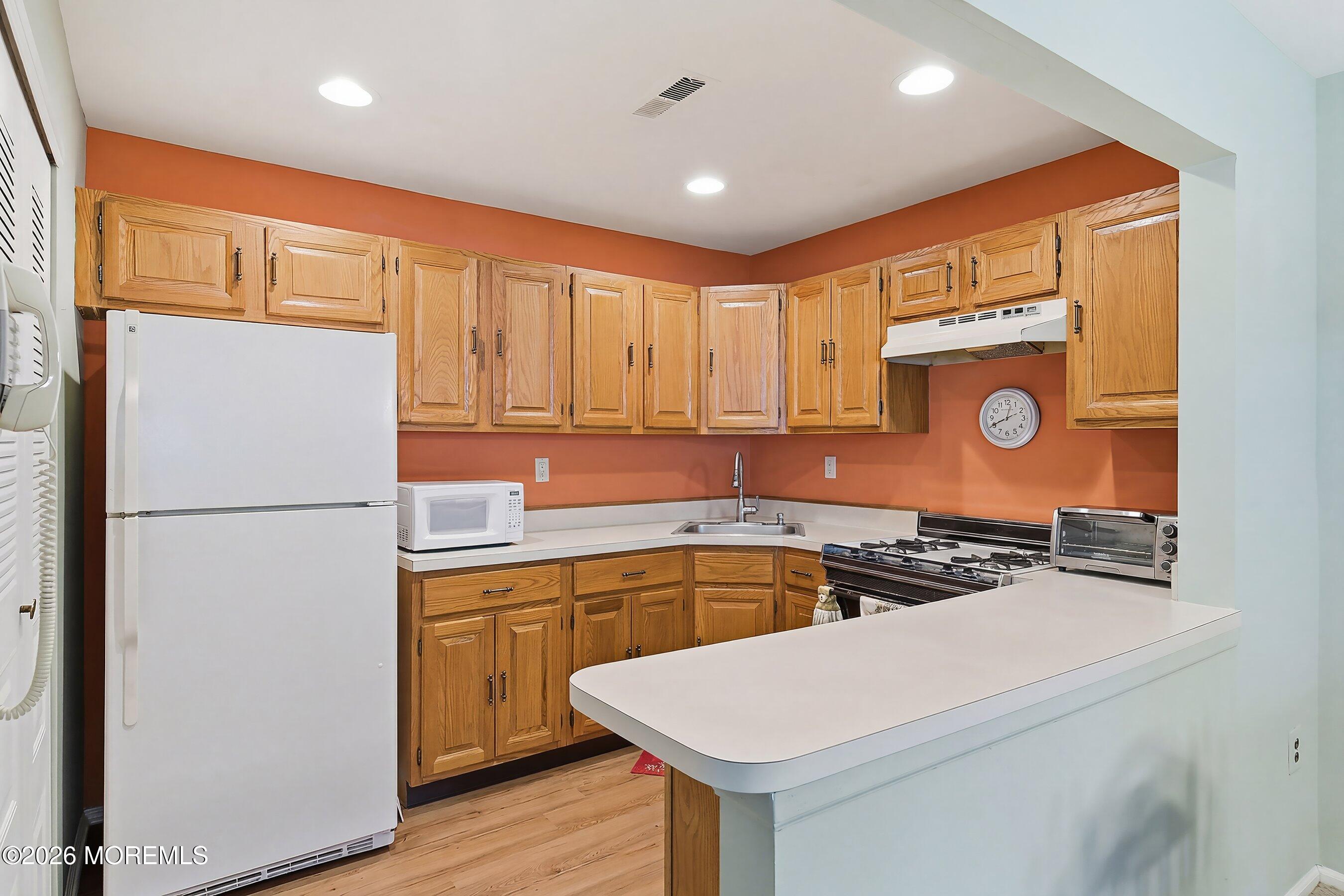 52 Honeysuckle Lane, Unit 220 Red Bank, NJ 07701 - Photo 11 of 25 a kitchen with a refrigerator sink and stove