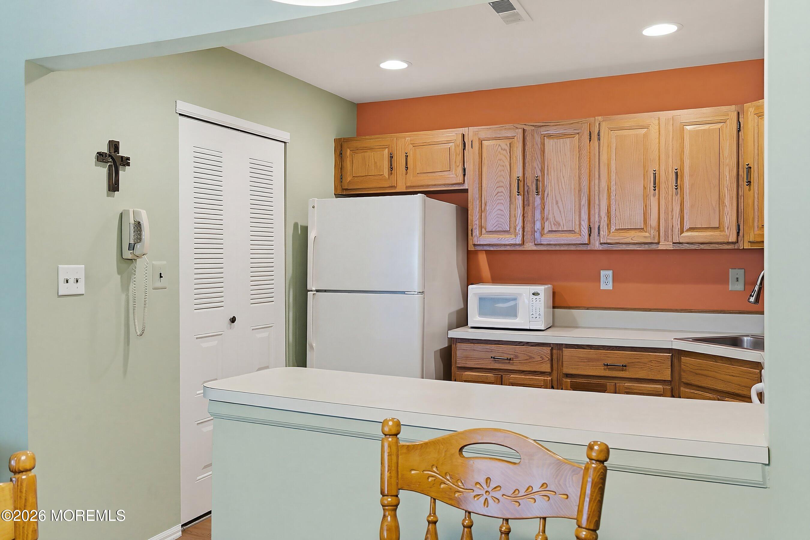 52 Honeysuckle Lane, Unit 220 Red Bank, NJ 07701 - Photo 24 of 25 a kitchen with a refrigerator a stove top oven a sink and cabinets
