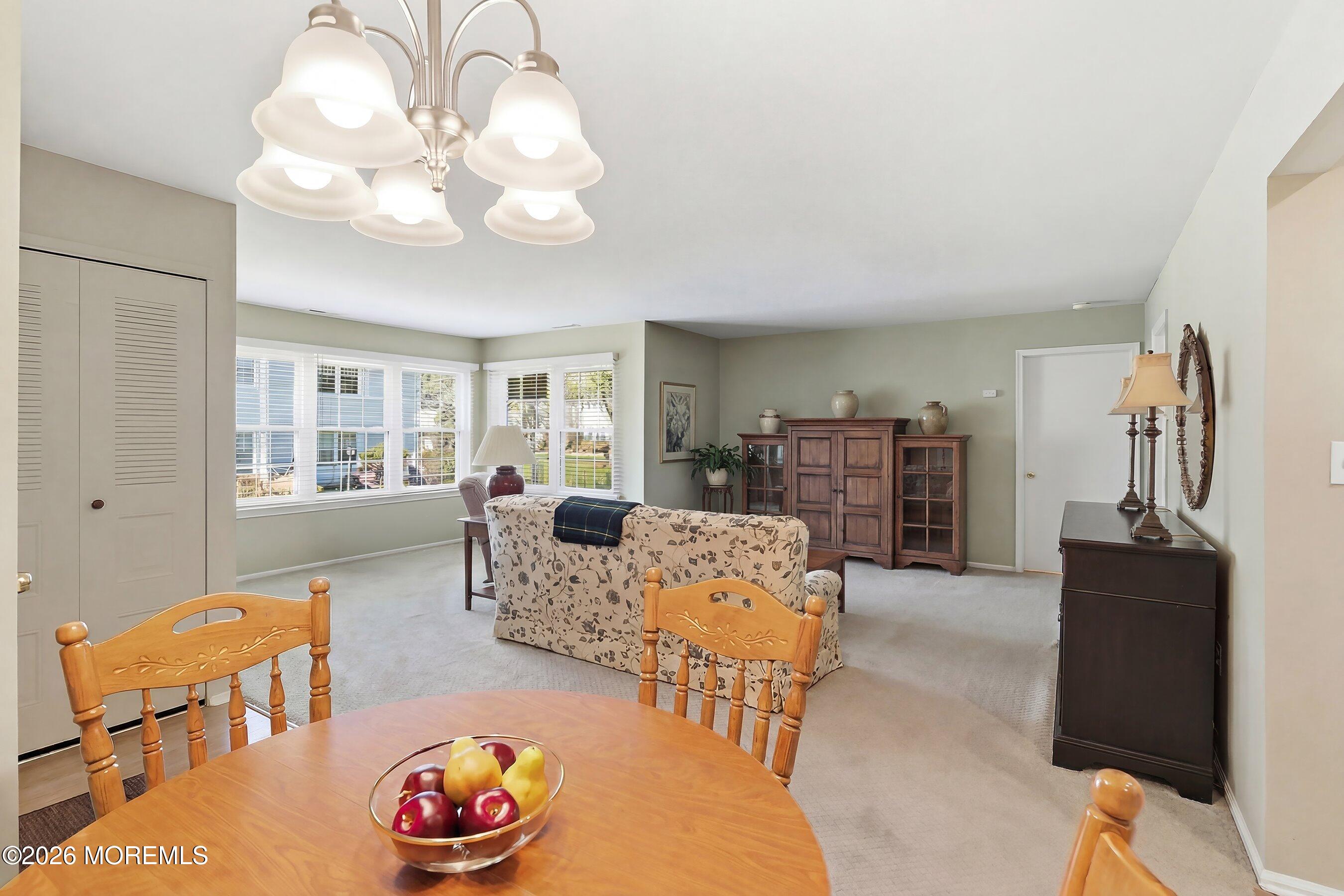 52 Honeysuckle Lane, Unit 220 Red Bank, NJ 07701 - Photo 9 of 25 a living room with furniture a chandelier and a dining table