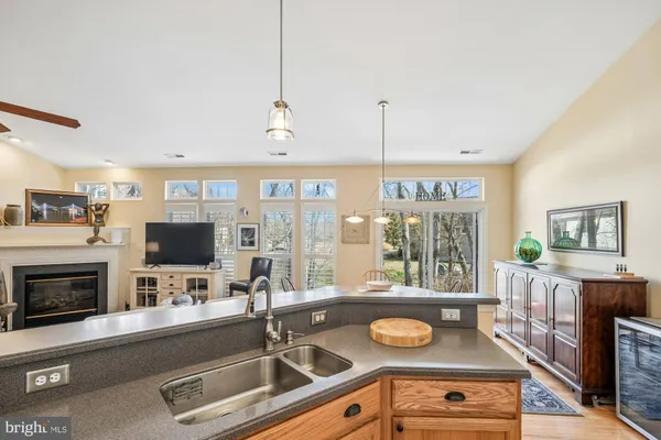 a kitchen with stainless steel appliances granite countertop a refrigerator a stove and a sink with wooden floor