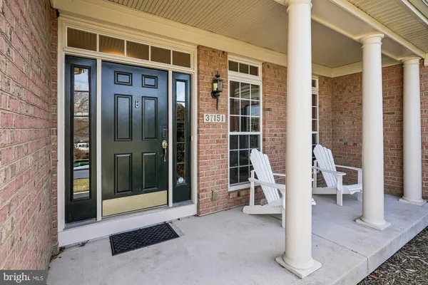 a living room with furniture a dining table and a large window