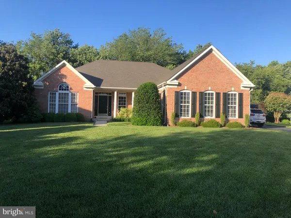 a view of a house with backyard and bushes