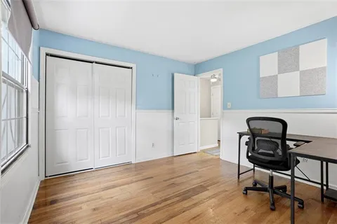 a view of a workspace with wooden floor and furniture