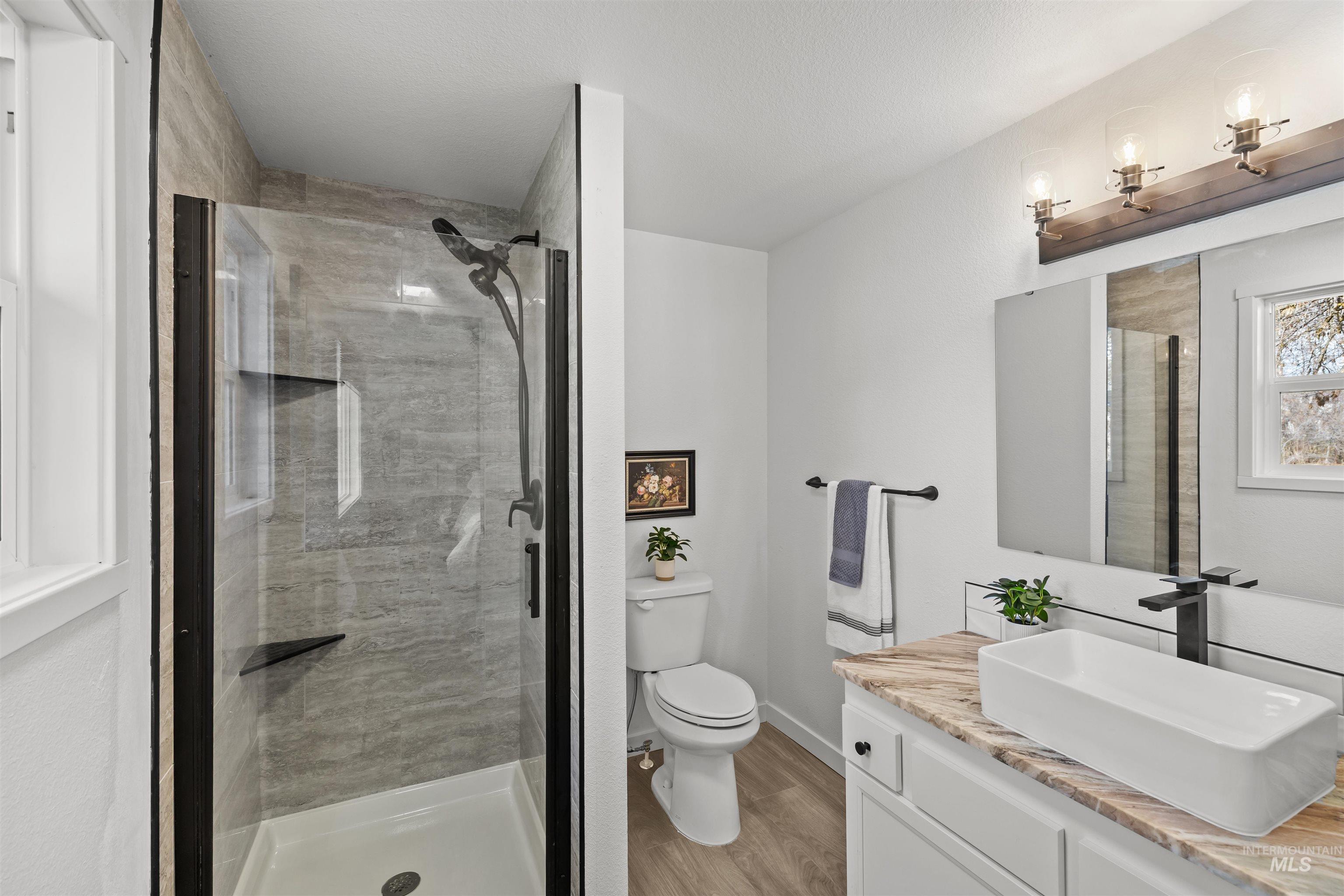 7144 West Diamond Street Boise, ID 83709 - Photo 18 of 47 Bathroom featuring vanity, a stall shower, and light wood finished floors