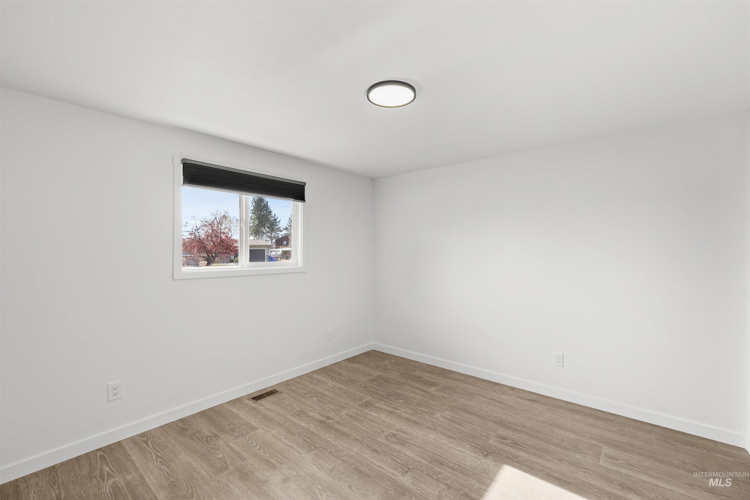 7144 West Diamond Street Boise, ID 83709 - Photo 19 of 47 Spare room featuring wood finished floors and baseboards