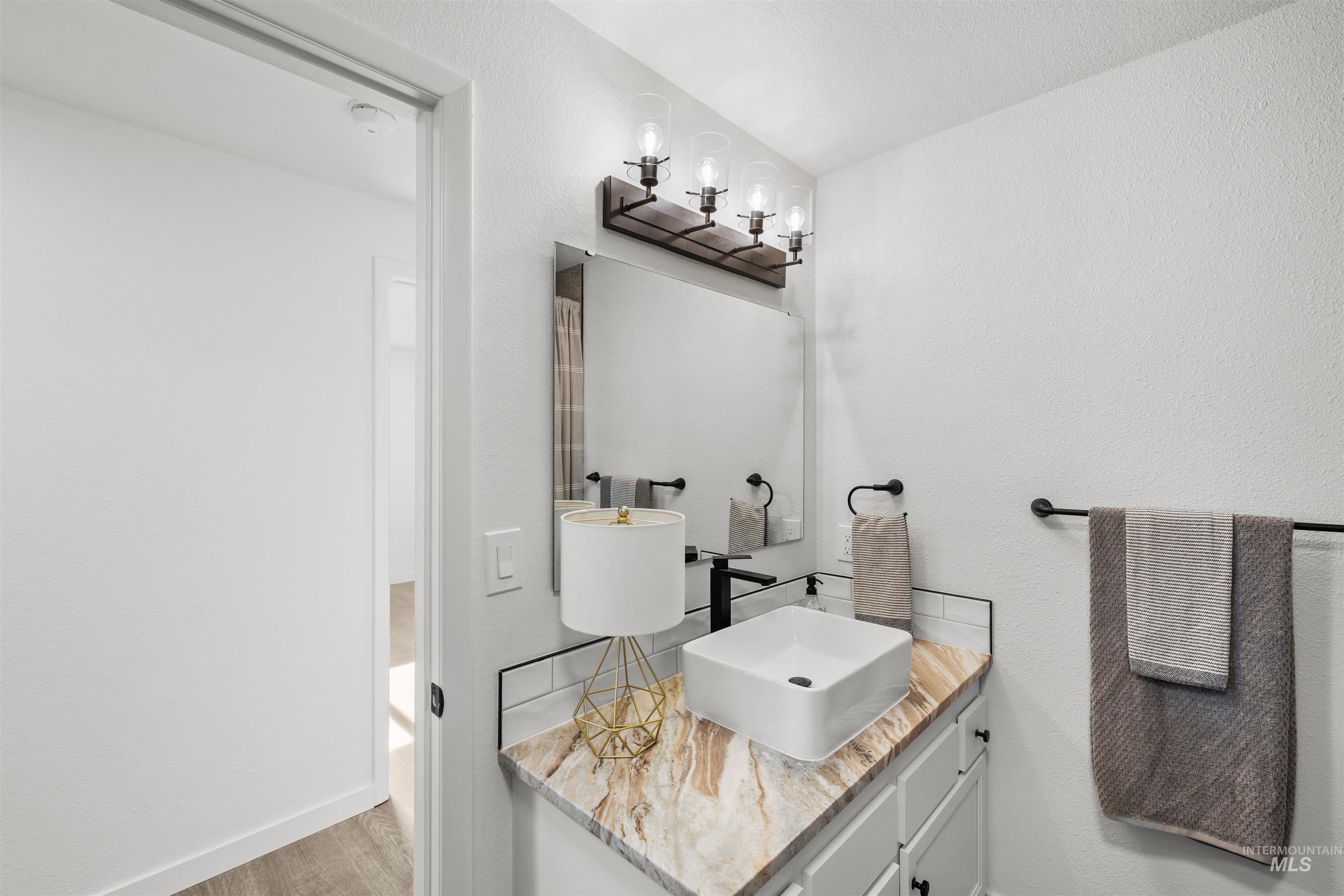 7144 West Diamond Street Boise, ID 83709 - Photo 22 of 47 Bathroom featuring a textured wall, vanity, and light wood-style flooring