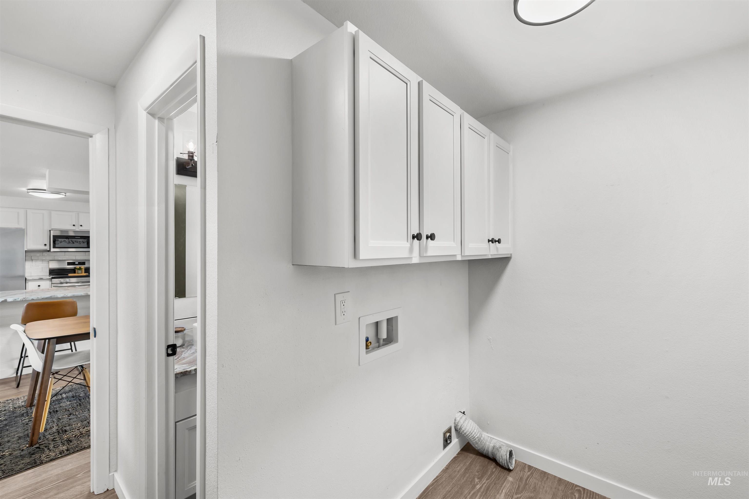 7144 West Diamond Street Boise, ID 83709 - Photo 25 of 47 Laundry area with light wood-style floors, hookup for a washing machine, and cabinet space