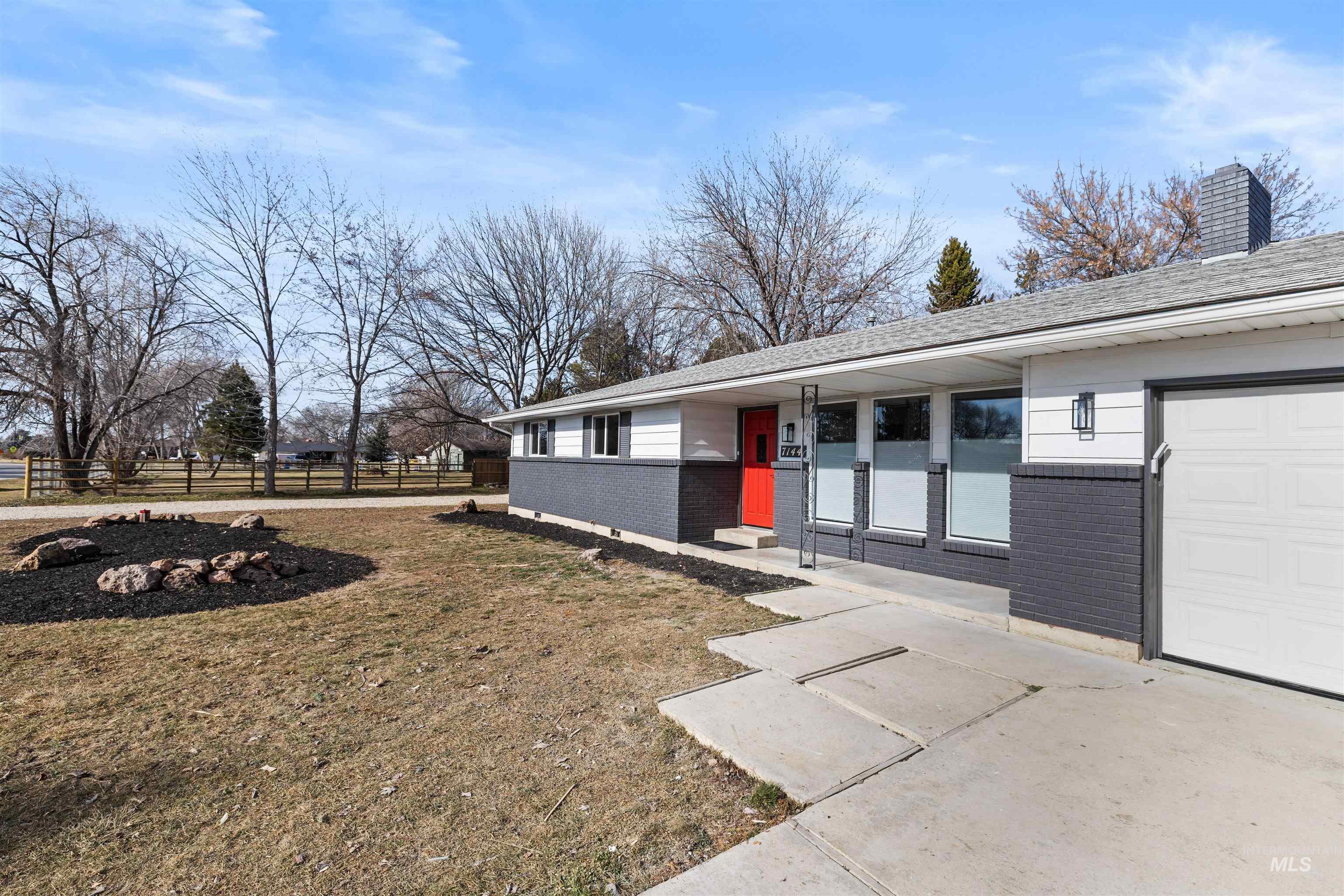 7144 West Diamond Street Boise, ID 83709 - Photo 4 of 47 View of home's exterior featuring brick siding, a garage, and a chimney