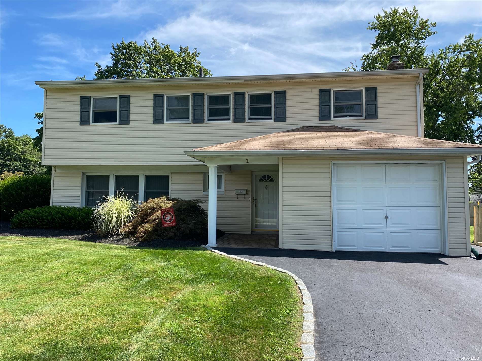 a front view of a house with a garden and yard