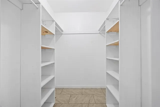 a view of walk in closet with empty racks