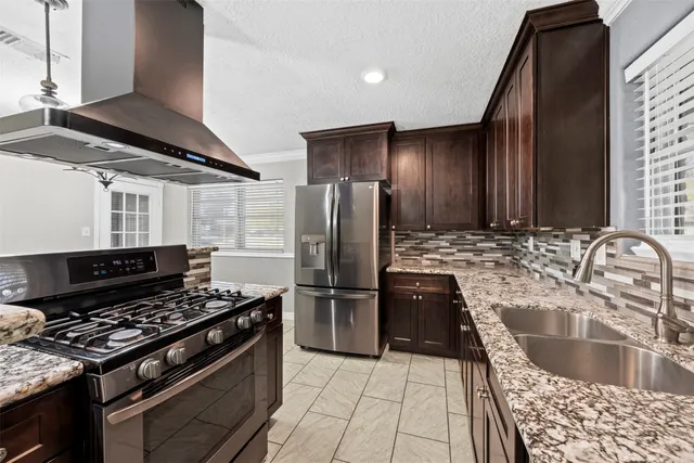 a kitchen with granite countertop a stove and a refrigerator