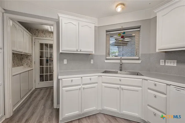a kitchen with white cabinets and white appliances