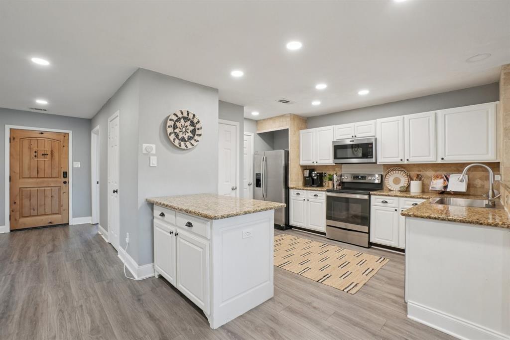 7006 Burning Bush Sachse, TX 75048 - Photo 12 of 39 a kitchen with granite countertop a sink cabinets and stainless steel appliances