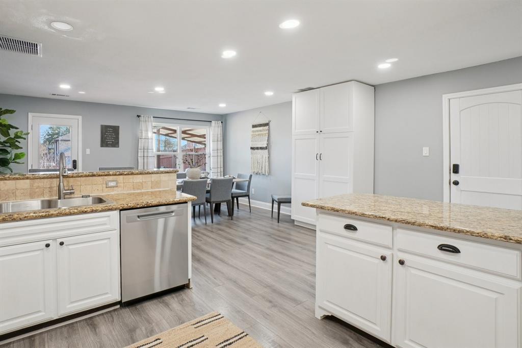 7006 Burning Bush Sachse, TX 75048 - Photo 15 of 39 a spacious kitchen with stainless steel appliances granite countertop a sink and cabinets