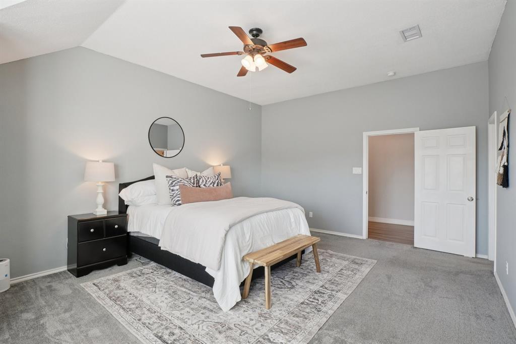 7006 Burning Bush Sachse, TX 75048 - Photo 21 of 39 a bedroom with a bed and a chandelier