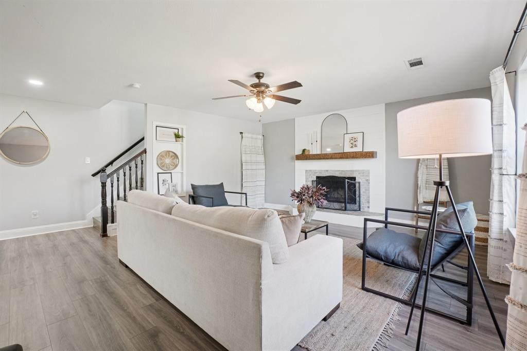 7006 Burning Bush Sachse, TX 75048 - Photo 9 of 39 a living room with fireplace furniture and a wooden floor