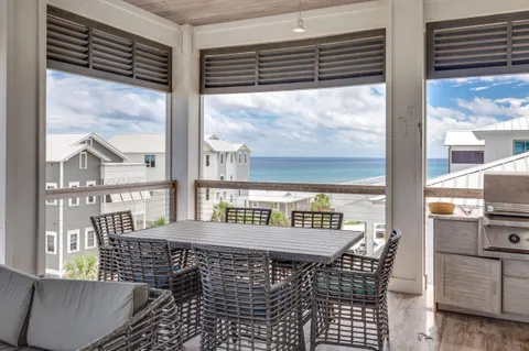 a living room with furniture and floor to ceiling windows