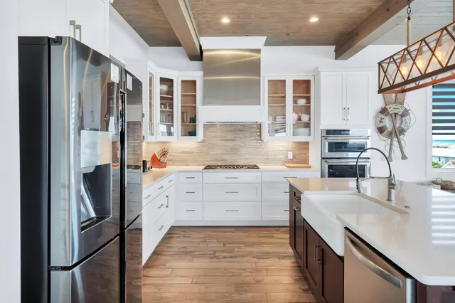 a large kitchen with a table chairs refrigerator and a wooden floor