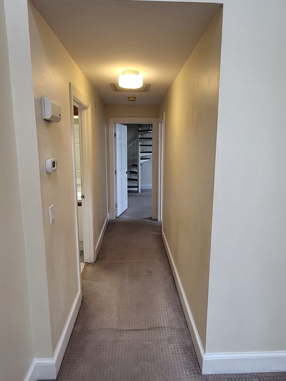 35 Walden Street, Unit 3B Cambridge, MA 02140 - Photo 11 of 39 a view of a hallway with wooden shelves