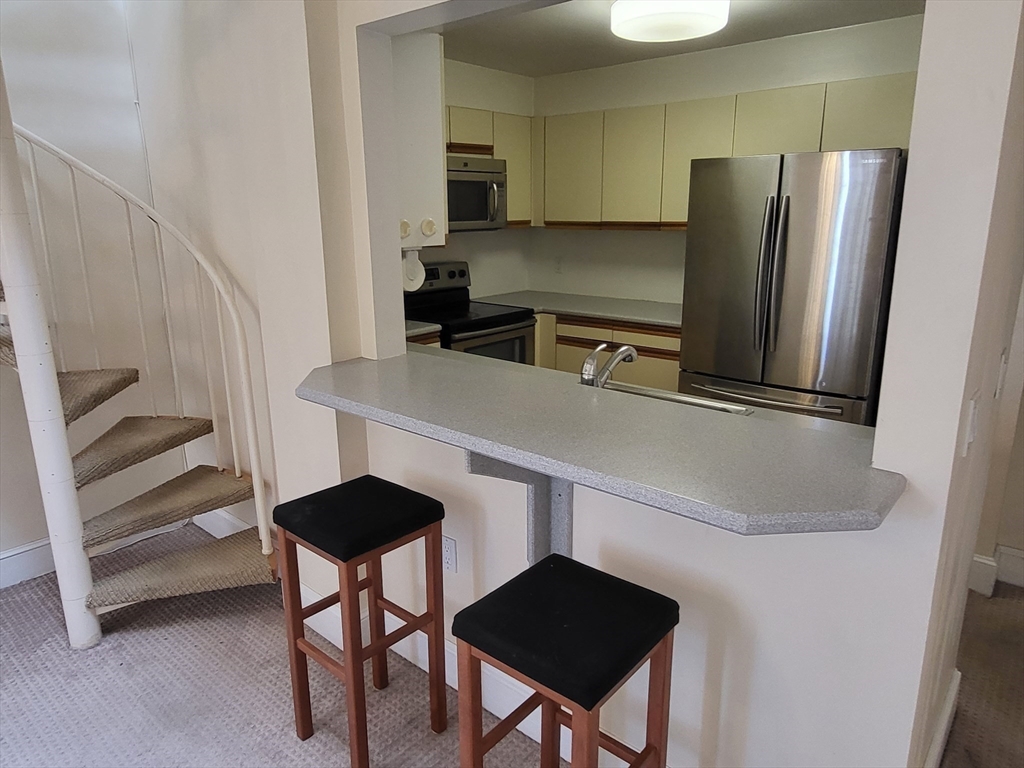 35 Walden Street, Unit 3B Cambridge, MA 02140 - Photo 8 of 39 a kitchen with stainless steel appliances a refrigerator and a stove top oven