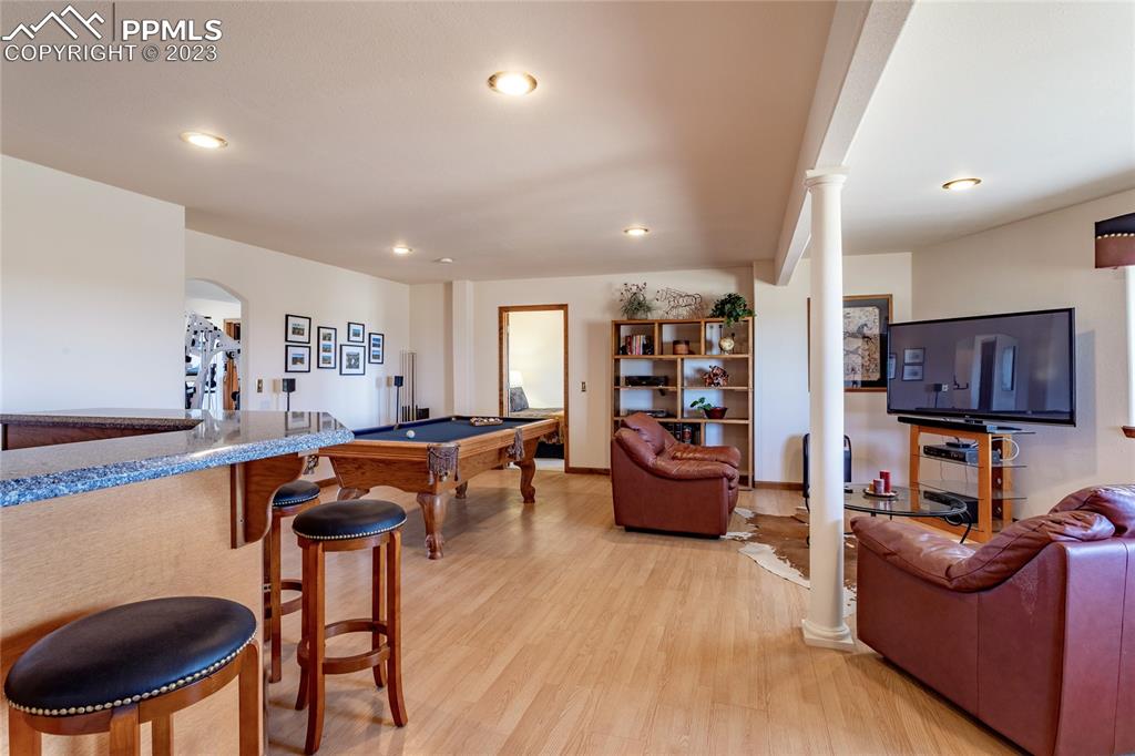 18165 Pinon Park Road Peyton, CO 80831 - Photo 26 of 44 a living room with furniture a flat screen tv and kitchen view