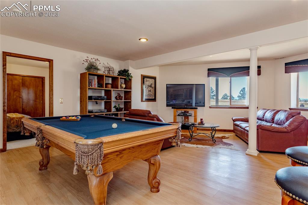 18165 Pinon Park Road Peyton, CO 80831 - Photo 27 of 44 a living room with furniture a desk and chair with wooden floor